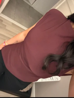 Vinröd ärmlös topp med hög hals - Säljer en vinröd topp med hög hals och ärmlös design. Toppen har en clean och stilren look med figurnära passform och lätt stretchigt material. Perfekt att styla med både jeans och kjol för en snygg outfit.