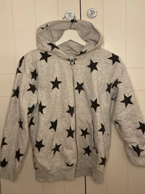 Grå zip hoodie  - En grå zip hoodie med stjärnor. 