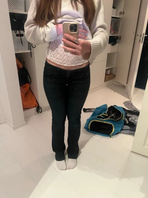 Svarta lågmidjade jeans - Säljer ett par svarta jeans med låg midja och klassisk femficksdesign. Jeansen har en rak passform och är tillverkade i ett stretchigt bomullsmaterial för skön känsla. Perfekta till en avslappnad look och passar till det mesta.