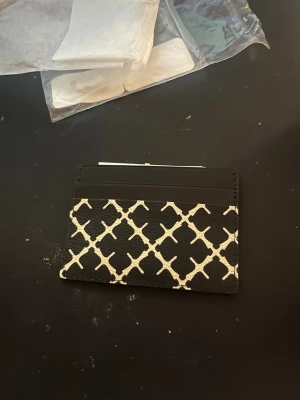 Svartvit korthållare By Malene Birger - Snygg korthållare från By Malene Birger i svart och vitt med ett rutigt grafiskt mönster. Säljer då jag ej hann skicka tillbaka i tid.