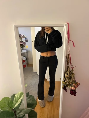 Svarta bootcut kostymbyxor - Säljer ett par svarta kostymbyxor med bootcut passform och midwaist. Byxorna har bälteshällor, diskreta fickor och stängs med dragkedja och knapp. Perfekta till en clean och stilren look. Materialet känns som en mjuk blandning med polyester.