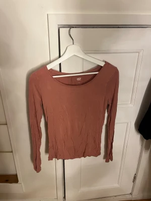 Rosa långärmad topp från 157 - En enkel och stilren långärmad topp från 157 i en varm rosa färg. Modellen har rund halsringning och är figurnära. Tillverkad i mjuk viskosblandning med stretch för skön passform. Perfekt att matcha med jeans eller kjol.