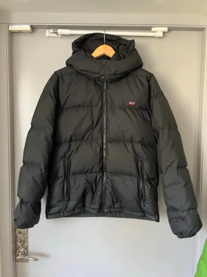 Levis dunjacka S - Varm, snygg och otroligt skön vinterjacka från Levi’s i 100% dun. Köptes ny förra året i New York för ca 2800kr och är bara använd ett par gånger. Finns en liten skråma på ryggen men som absolut inte märks vid användning. Annars väldigt fint skick