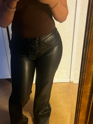 Svarta läderbyxor byxor med snörning - Säljer ett par lågmidjade Skinnbyxor i strl M. Helt slutsålda på hemsidan! Och prislappen är kvar 