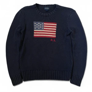 Mörkblå stickad tröja Polo Ralph Lauren | L -14-16 - Mörkblå stickad tröja från Polo Ralph Lauren. Nypris cirka 6000 kr. Tröjan har några små fläckar (kolla bild 4) men väldigt svårfunna, tröjan är i övrigt mycket bra skick!