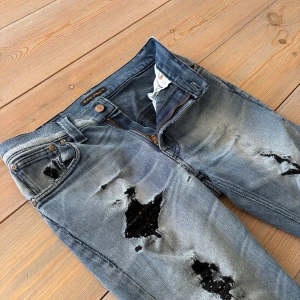 Blå slitna Nudie Jeans - snygg vitagelook🎞️ - Slitna jeans från Nudie jeans i strl 30/32. Slim/tajt fit, snygg sliten look - perfekt till dig som gillar en sliten look. Jeansen har igen sydda hål men det ändrar inte helhetsbilden. 🎩Unik look 💙Snygg blå färg🎯Just nu endast 399kr!🚚Passa på medans frakten är gratis!