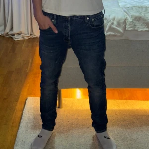 Blå jeans från Superdry - Säljer ett par klassiska blå jeans från Superdry i storlek 32/32. Jeansen har en snygg tvätt med lätt slitning, raka ben och fem fickor. Perfekt passform och stilren look som funkar till det mesta. Materialet är mjukt och skönt denim.