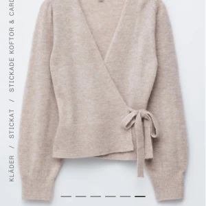 Beige omlottkofta från & Other Stories - Superfin beige omlottkofta från & Other Stories med knyt i sidan och bred ribbad mudd. Koftan har lång ärm och är stickad i mjukt material💗 Lite nopprig men vet inte om det ska vara så för den va så när jag fick den och inget man tänker på. 