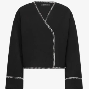 Svart omlott overshirt kappa  från Gina Tricot - Svart overshirt från Gina Tricot med vit dekorativ söm längs kanterna. Jackan har omlott-design med knappar🩷