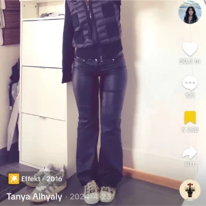 Svarta bootcut byxor i skinnlook - Snygga svarta byxor i skinnimitation med bootcut och klassisk femficksdesign. Byxorna har en tight passform upptill och utsvängda ben, vilket ger en riktigt trendig siluett. Perfekta för dig som vill sticka ut med en edgy vibe.