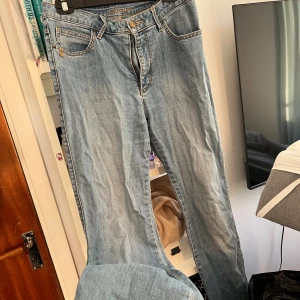 Lågmidjade jeans - Flash Jeans ”Sanna” - Lågmidjade jeans från Flash Jeans med klassisk femficksdesign och snygga kontrastsömmar. Modellen har raka ben och normal passform. Broderad logga 'Sanna' vid linningen och läderpatch bak. Perfekta för en avslappnad och stilren look.