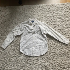 Vit kofta med dragkedja från East West - Säljer en stilren vit ribbstickad kofta från East West i storlek S. Koftan har hel dragkedja framtill, hög krage och långa ärmar. Perfekt för lager-på-lager och enkel att matcha med allt. Superfräsch och passar till många olika looks.