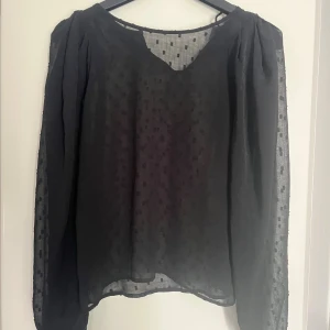 Svart blus från Lindex - Jättefin svart blus från lindex som är lite genomskinlig med svarta små prickar