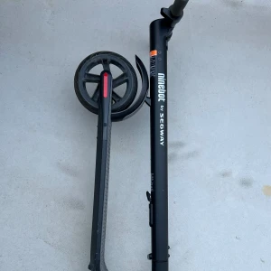 Ninebot by Segway elscooter - Ninebot by Segway elscooter i gott skick, med laddare. Stabil konstruktion, stora hjul och bekvämt styre. Några tecken på normalt bruksskick på hjulen, men inga synliga större skador. Perfekt för smidig och miljövänlig transport i staden.