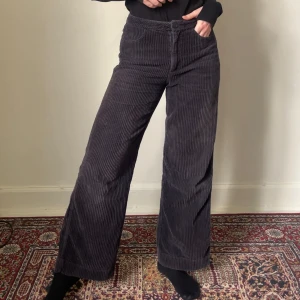 Marinblå manchesterbyxor från Weekday - Säljer ett par svarta manchesterbyxor från Weekday i 100% bomull. Byxorna har hög midja, raka ben med wide fit och klassiska fickor fram. Stängs med knapp och dragkedja. Är så galet sköna att ha på sig, som en pyjamas man kan ha till skolan/jobbet! Perfekta för dig som gillar en chill och trendig look.