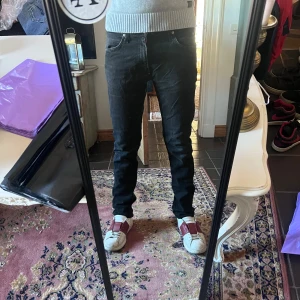 Svarta Lee Luke slim jeans 32/32 - Säljer ett par svarta jeans från Lee med skinny fit och klassisk femficksdesign. Jeansen har en mörk tvätt och raka ben med smal passform. Materialet är stretchigt jeans för extra komfort. Perfekta för dig som gillar en stilren och enkel look.                                                                 Modellen är 178cm 70 kg midja 40cm  längd 103cm (5)