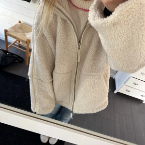 Beige teddyjacka från hm😍😍 - Supermjuk och oversized teddyjacka i beige med stora fickor framtill och hel dragkedja. Jackan har hög krage och breda ärmar, perfekt för att hålla värmen under kyliga dagar. Snygg och enkel att matcha till jeans eller mjukis.