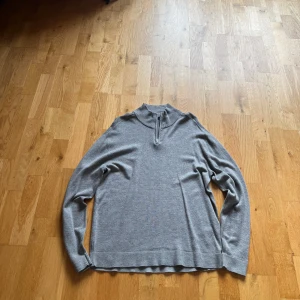 Grå stickad half zip-tröja  - Snygg grå stickad tröja från lager  157 med ribbad krage och half zip-dragkedja. Perfekt för lager-på-lager och chill stil. Långärmad modell med relaxed fit och mjukt material som känns skönt mot huden. Nypris ca 300kr