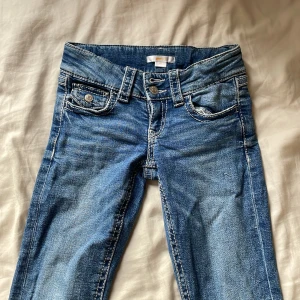 Blå jeans från Gina Tricot, stl 146 - Snygga blå jeans från Gina Tricot i storlek 146. Klassisk femficksmodell med tydliga kontrastsömmar och normal passform. Jeansen har en lätt tvättad look och är tillverkade i mjukt denimtyg med knapp och dragkedja framtill.