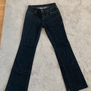 Mörkblå bootcut jeans - Snygga mörkblå jeans med bootcut passform och klassiska fickor. Jeansen har en normal midja och är tillverkade i ett robust denimtyg. Perfekta för dig som gillar en tidlös och stilren look.