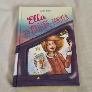 Ella och Youtube-paniken - En färgglad och rolig bok om Ella som drömmer om att bli YouTube-kändis. Med humor och äventyr, guld­fiskar och klickmonster, passar den perfekt för unga läsare. Fick boken från en Girl:IT tidning för några år sedan. I mycket bra skick, endast läst en gång och på svenska.