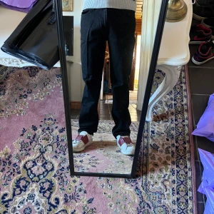 Svarta raka jeans från Lee - Säljer ett par svarta jeans från Lee med klassisk femficksdesign och raka ben. Jeansen har normal passform och midja, tillverkade i ett mjukt bomullstyg med lite stretch för extra komfort. Perfekta för dig som gillar en clean och tidlös look. (10) modellen är 178cm 70kg midja 42cm längd 106cm (10)