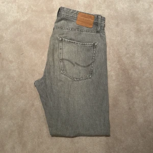 Grå jeans - Gråa jeans ifrån Jack and Jones i färgen grå, storleken är 32/34. Modellen är chris