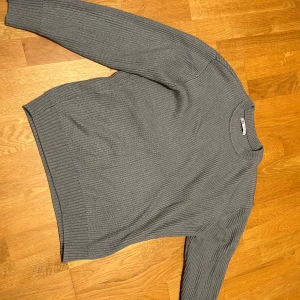 Grå/turkos stickad tröja från Zara - Säljer en stilren grå ribbstickad tröja från Zara. Tröjan har rund halsringning och långa ärmar, perfekt för lager-på-lager. Enkel att matcha med jeans eller kjol för en clean look.