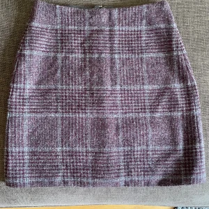 Pennkjol rutig - Lila pennkjol i ull från okänt märke, passar strl s/m. Dragkedja på baksidan