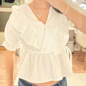 Vit söt gullig blus topp volanger rosett bow ribbon coquette babydoll milkmaid peplum volang - Supersöt topp som är köpt utomlands! Står ingen storlek, passar bäst som XS-S.  Blusen ser nästan exakt likadan ut på både framsida och baksida.