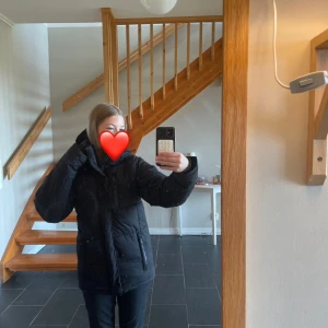 Svart pufferjacka med huva - Superfin svart varm jacka, använd en säsong älskar hur varm och skön den är men säljer då jag är sugen på något nytt 🩷 den är storlek xs och passar mig som vanligtvis brukar ha xs - s❤️