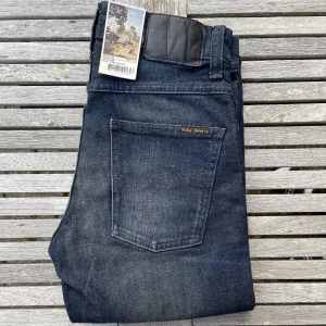 Nya Nudie Jeans Grim Tim - Säljer du dessa otroligt snygga Nudie jeans! De är storlek 28/32 och modell Grim Tim. Helt sprillans nya med tags, alltså helt oanvända! Sjukt snygg och unik tvätt och färg! Nypris är 1600 online! Hör av dig vid frågor och funderingar, priset är inte hugget i sten! 