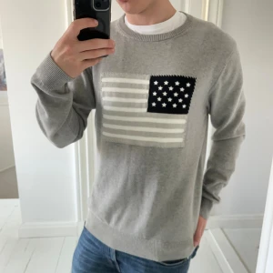 Gant tröja grå usa flagga  - Gant tröja grå usa flagga i storlek L. Modellen är 180,75 kg lite stor på honom! ✌️inga defekter 