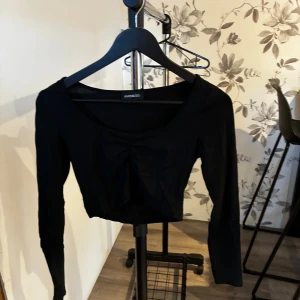 Croptop  - Svart långärmad croppad topp från Even&Odd med v-ringning och snygg rynkdetalj framtill. Toppens material är mjukt och stretchigt, perfekt för en trendig look. Enkel att matcha med både jeans och kjol.