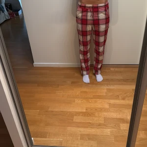 Röd-rutiga byxor från Kappahl XS - Pyjamas byxor från Kappahl i röd och vit rutig design. De har elastisk midja med snörning och raka ben. Perfekta för chill dagar hemma. Tillverkade i mjuk bomull för extra komfort.
