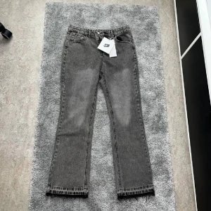 Grå raka jeans med tvättad look - Snygga grå jeans med tvättad effekt och raka ben. Klassisk femficksmodell med knapp och dragkedja i midjan. Perfekta för en avslappnad och trendig stil.