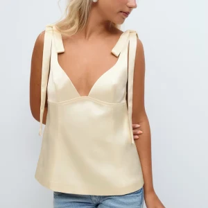 Slutsåld Gul satin topp från Gina  - Säljer denna slutsålda gula satin toppen från Gina tricot Young 14+. Toppen är använd en gång och är i superfint skick, som ny. Jag säljer för att den inte kommer till användning! Nypris 350kr, hör av dig om du har frågor.