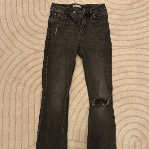 Jeans från Gina Tricot  - Gråa jeans från Gina Tricot med hål, stl 34