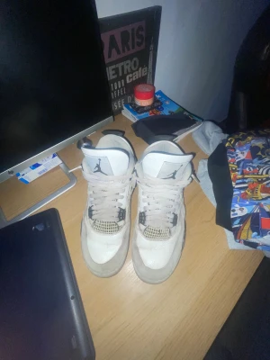 Nike Air Jordan 4 Retro Military black  - Säljer ett par Nike Air Jordan 4 Retro i vitt och svart med klassisk Jumpman-logga på plösen och hälen. Skorna har meshpaneler, snörning och detaljer i svart och grått. Ovandelen är i skinn och mesh för en ikonisk look. Perfekta för dig som vill sticka ut med en tidlös sneaker. Ser lite smutsiga ut men ska tvätta dem så dem ser helt nya ut 