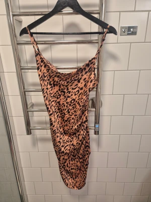 Leopardmönstrad klänning PrettyLittleThing - Säljer en snygg leopardmönstrad klänning från PrettyLittleThing i storlek 34. Klänningen är kort, figurnära och har tunna axelband.
