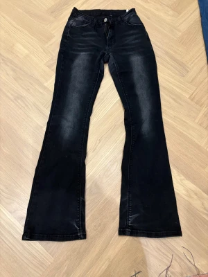 Svarta bootcut jeans från SHEIN XS - Svarta jeans från SHEIN i bootcut-modell med klassisk femficksdesign. Jeansen har en lätt tvättad look och är tillverkade av bomull, polyester och elastan för skön stretch. Passar dig som gillar en snygg siluett med lite utsvängda ben.