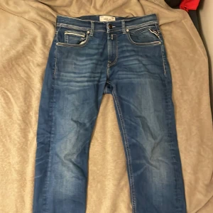 Replay Hyperflex Grover jeans blå - Snygga blå Replay Hyperflex Grover jeans med klassisk femficksdesign och raka ben. Jeansen har coola slitningar och kontrastsömmar, tillverkade i stretchigt denim för extra komfort. Perfekta för dig som gillar en stilren och avslappnad look. Innerbenens måtten är kortare för Nk har sytt upp dom för min pass form så dom är 72 i längd nu. Ny pris 1800kr Pris kan diskuteras mvh Axel 🤩