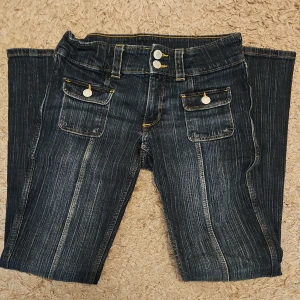 Mörkblå bootcut jeans med fickor från H&m - Jag säljer ett par jättesnygga mörkblå lågmidjade jeans med bootcut passform och coola framfickor med lock och knappar i storlek 152. Endast använda två gånger och därför i mycket bra skick. Nypris runt 200 kr. Säljer då jag tyvärr inte får användning utav de längre. 