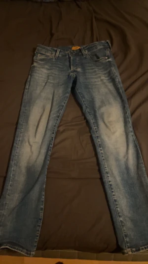 Slim fit jeans från Jack & Jones - Snygga blå jeans från Jack & Jones i slim fit-modell. Jeansen har klassisk femficksdesign, ljusa slitningar och en ren look. Tillverkade i jeansmaterial med bekväm passform och medelblå tvätt. Skulle säga att dem är exakt som ett par Replay Hyperflex i passformen. Storlek W31/L32. Hör gärna av er vid frågor eller funderingar. Pris kan diskuteras vid en snabbaffär😁
