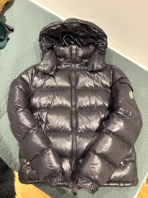 Moncler Maya  - Perfekt vinter jacka nu mitt i vintern, håller värmen och sitter som en smäck är ledsen att behöva sälja den men den har blivit för liten. Har ni frågor och funderingar hör av er till mig.
