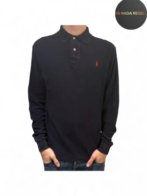 Mörkblå långärmad pikétröja Ralph Lauren - Snygg mörkblå långärmad pikétröja från Ralph Lauren i mycket fint skick! Jag på bilden är 184cm lång 70kg. Hör av er vid frågor eller funderingar!