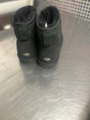 Svarta UGG - Mysiga svarta UGG boots. Utsidan är i mjuk mocka och insidan är fodrad med fluffigt fårskinn som håller fötterna varma. Klassisk UGG-logga baktill och mönstrad gummisula för bra grepp. Perfekt för kalla dagar.😇💗