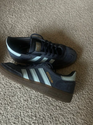 Adidas Spezial sneakers marinblå - Säljer ett par Adidas Spezial sneakers i marinblå mocka med ljusblå ränder och detaljer. Guldtexten 'Spezial' på sidan.