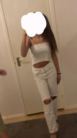 Vita jeans med hål vid knäna - Säljer ett par vita jeans med snygga hål vid knäna och klassisk femficksdesign. Köpt för 360kr från Gina young, storlek 160. Byxorna har rak passform och normal midja, perfekta för dig som gillar en clean och trendig look. Materialet är jeans och färgen är helvit.