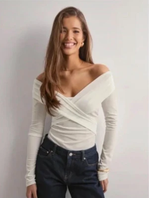 Vit off-shoulder body i sammet från Nelly - Supersnygg vit body från Nelly i mjuk sammet med omlott-detalj och offshoulder. Långärmad och figurnära passform. Riktigt fin och prislappen är kvar
